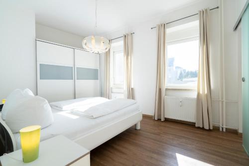 シャルボイツにあるFerienwohnung Capolinoの白いベッドルーム(ベッド1台、シャンデリア付)