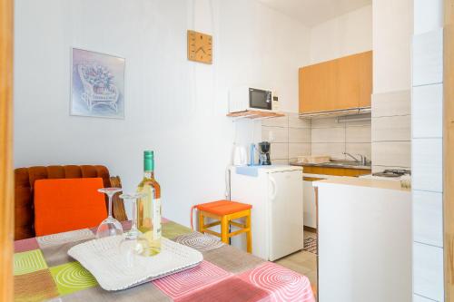 CHEAP apartment TANJA في تروغير: مطبخ مع طاولة مع زجاجة من النبيذ عليه