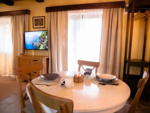 een eetkamer met een tafel en een televisie bij Spirit of the Earth Cottage Dobogókő in Pilisszentkereszt