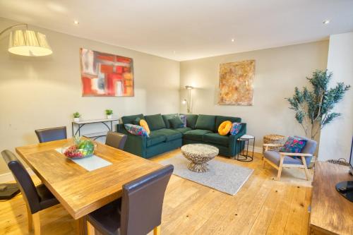 a living room with a green couch and a table at Centrally Located Apartment - Pass the Keys in Lincoln