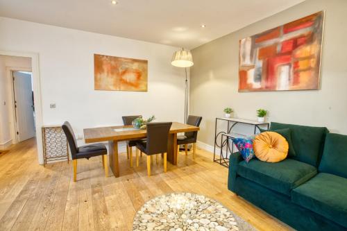 a living room with a green couch and a table at Centrally Located Apartment - Pass the Keys in Lincoln