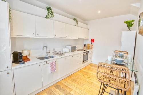 a kitchen with white cabinets and a table and chairs at Centrally Located Apartment - Pass the Keys in Lincoln