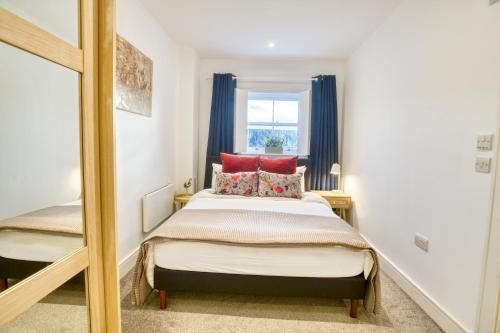 a bedroom with a bed with red pillows and a mirror at Pass the Keys Centrally Located Apartment in Lincoln