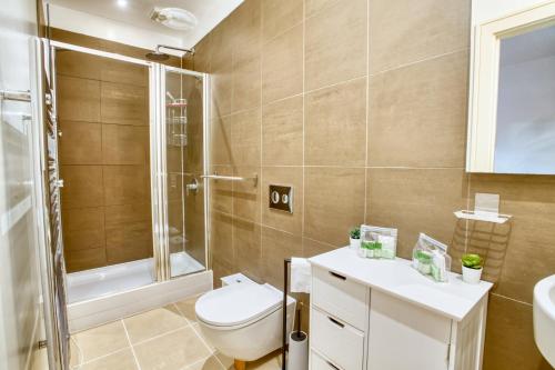 a bathroom with a toilet and a shower and a sink at Pass the Keys Centrally Located Apartment in Lincoln