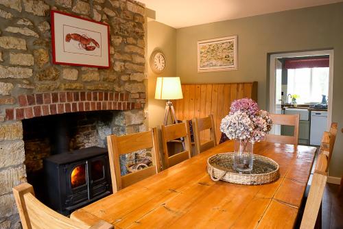 a living room with a wooden table with a fireplace at Laverstock Cottage in Bridport