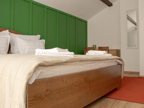 a bedroom with a large bed with a green wall at Chalet Deluț in Suceava