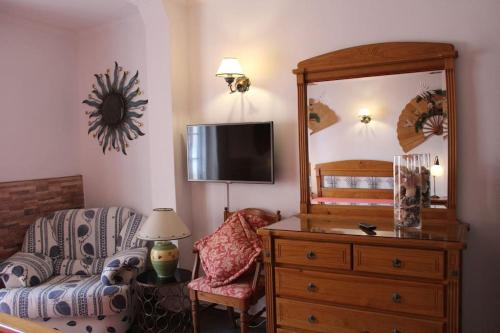 a living room with a chair a dresser and a mirror at Casa Andreia, close to everything in Lagos