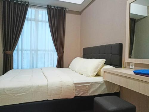 Un pat sau paturi într-o cameră la Apartemen Borneo Bay City Balikpapan