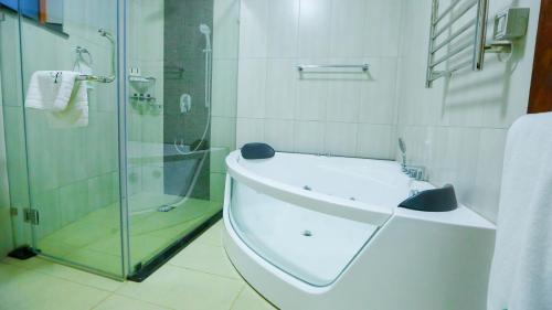 a bathroom with a glass shower and a sink at Aberdare Prestige & Royal Cottages in Nanyuki