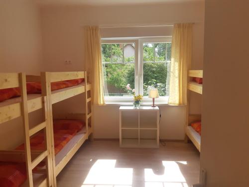 Cette chambre comprend 2 lits superposés et une fenêtre. dans l'établissement Schieszl Apartments Zamárdi 4, à Zamárdi