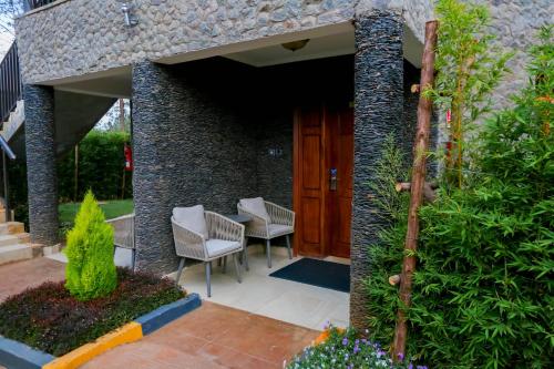 a patio with chairs and a wooden door at Aberdare Prestige & Royal Cottages in Nanyuki