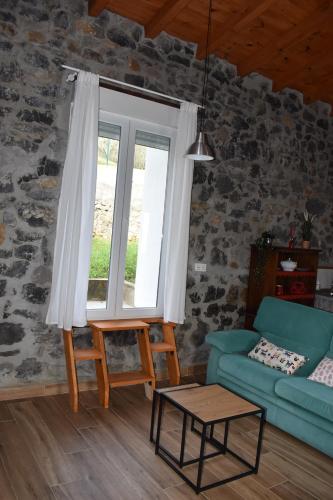 sala de estar con sofá azul y ventana en LA ANTIGUA CUADRA precioso apartamento de piedra con jardín, barbacoa y acceso al río, en Ramales de la Victoria