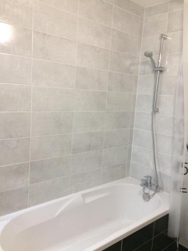 une baignoire blanche avec douche dans une salle de bain dans l'établissement F2 côté UGC climatisé plein centre parking gratuit, à Strasbourg