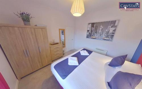 um quarto com uma cama e um armário de madeira em Sunnyside View - 1-bed Apartment in Coventry City Centre em Coventry