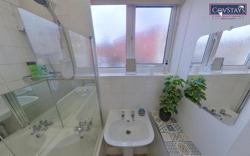 uma casa de banho com um lavatório e um chuveiro em Sunnyside View - 1-bed Apartment in Coventry City Centre em Coventry