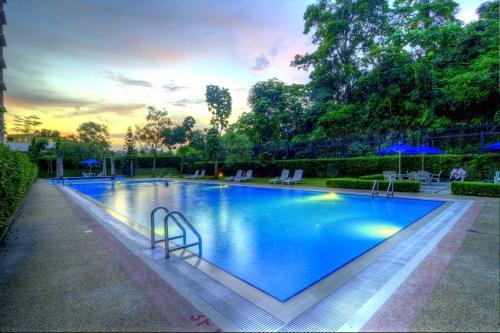 a large blue swimming pool with chairs and umbrellas at Wedgewood Residences in Kuala Lumpur