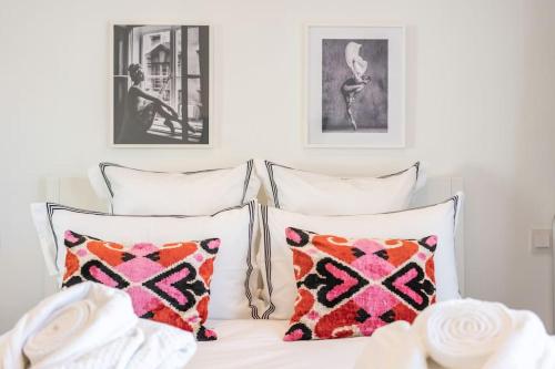 a bed with two pillows and two pictures on the wall at Luxury Apartment - 150m to Palais des Festivals ( Cannes ) in Cannes