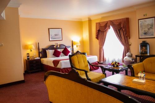 En eller flere senge i et værelse på Delmon International Hotel