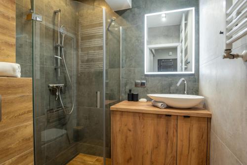 y baño con lavabo y ducha acristalada. en Apartament Słowackiego, en Karpacz