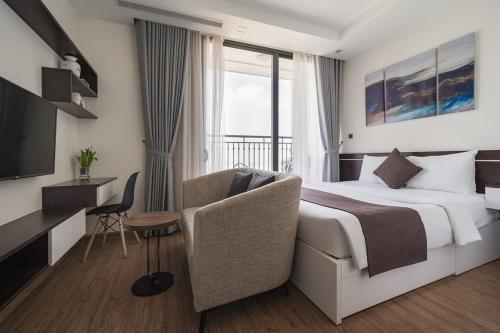une chambre d'hôtel avec un lit, un bureau et une télévision dans l'établissement Vinhomes Greenbay Mễ Trì Nam Từ Liêm Hà Nội, à Hanoï