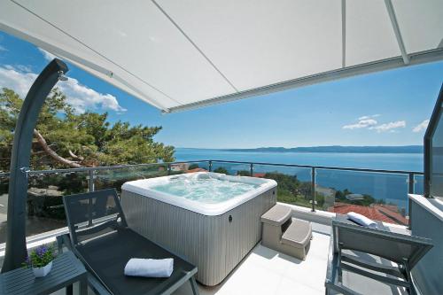 un jacuzzi en el balcón de una casa en Apartments Villa Nadalina Deluxe, en Brela