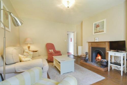 a living room with a living room with a fireplace at West Lodge in Newton by the Sea