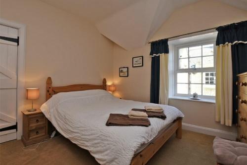 a bedroom with a bed with two towels on it at Turnstone Cottage in Bamburgh