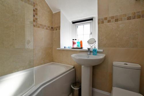 a bathroom with a sink and a tub and a toilet at Turnstone Cottage in Bamburgh