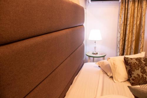 a bed with a brown headboard in a room at Hotel Imigrantes in Bento Gonçalves