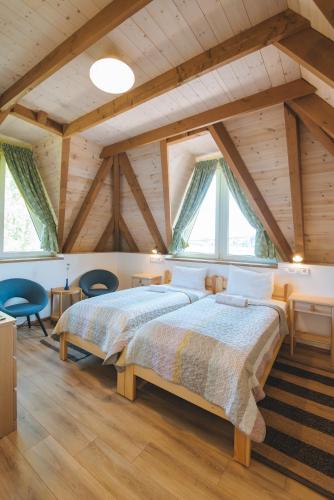 a bedroom with a large bed and wooden ceilings at Kormorán tóparti szobák in Katalinmajor