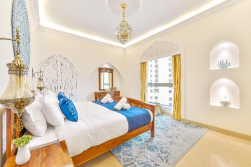 1 dormitorio con 1 cama con almohadas azules y blancas en Luxury JBR Palace! · Sea View · Free 5* Beach Resorts Access!, en Dubái