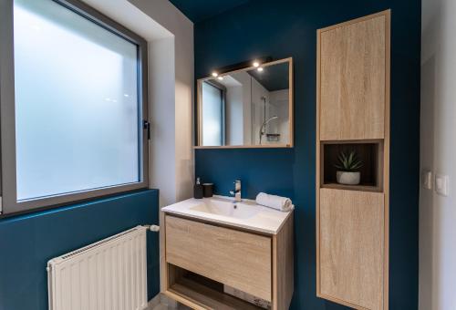ein Bad mit einem Waschbecken und einem Spiegel in der Unterkunft Maison de Village - 291 in Duingt