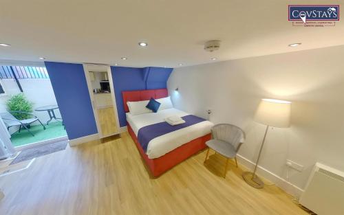 a bedroom with a bed and a table and a lamp at Cosy Escape - Studio Apartment in Coventry City Centre in Coventry