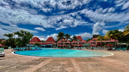 a swimming pool in front of a resort at Ti kaz COCO DOUCEUW sea view in Sainte-Anne