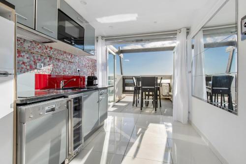 Il comprend une cuisine équipée d'appareils rouges et un balcon avec une table. dans l'établissement Senses at Sea, au Cap d'Agde