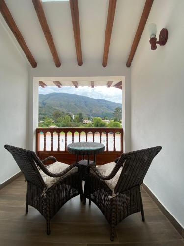 a table and chairs on a balcony with a view at Hotel las Palmas in Villa de Leyva
