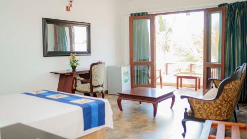 a bedroom with a bed and a table and chairs at Mother's Place Nimala in Hikkaduwa