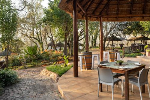 a patio with a table and chairs under a pavilion at Premier Hotel Roodevalley in Pretoria