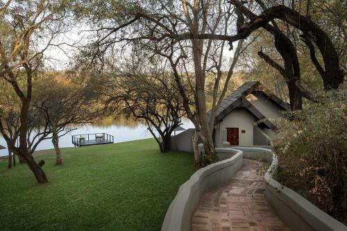 a house with a brick walkway leading to a yard at Premier Hotel Roodevalley in Pretoria