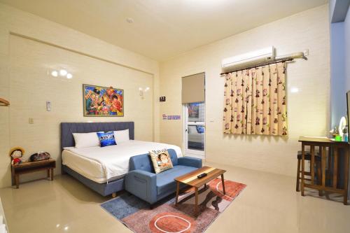 een slaapkamer met een bed en een blauwe stoel bij Piau Po 21 Inn in Taitung