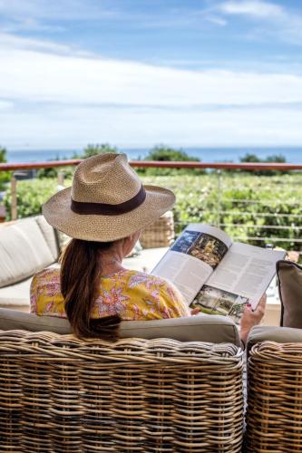 a woman sitting in a basket reading a book at Far Horizons Camps Bay in Cape Town