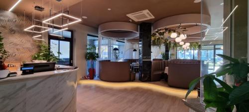 an office with a lobby with potted plants at Gotha Hotel Turin Airport in Ciriè
