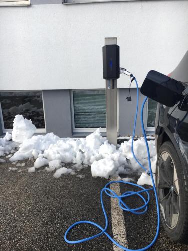 a car is covered in snow next to a meter at Aparthome L.I.N.Z. in Bergham
