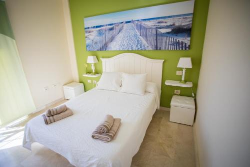 - une chambre avec un lit blanc et des serviettes dans l'établissement Orquídea Holiday Modern House, à Mogán