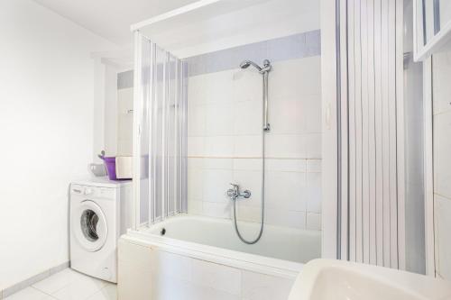 a white bathroom with a shower and a washing machine at Levanda Villas - Country villas with private pool in Exopoli