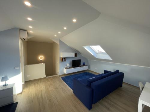 a living room with a blue couch and a skylight at Appartamento Luigi in Ventimiglia