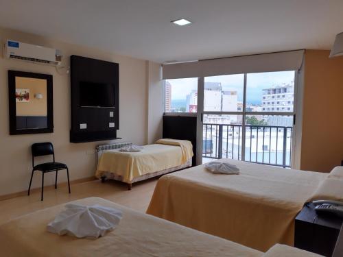 ein Hotelzimmer mit 2 Betten und einem Balkon in der Unterkunft Hotel Presidente in Villa Carlos Paz