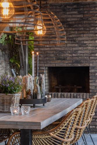 a table with chairs in front of a brick fireplace at Sjiek Basiliek in Oudenbosch