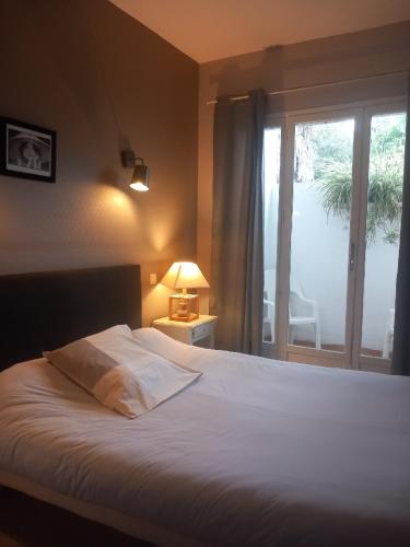 a bedroom with a large white bed with a window at Chez l'ahumat in Aire-sur-lʼAdour