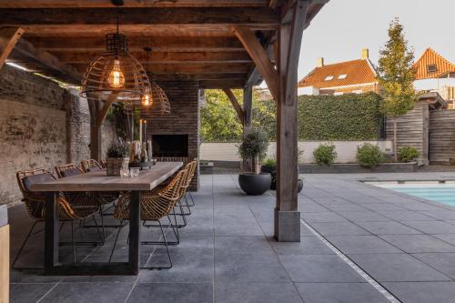 a patio with a table and chairs and a pool at Sjiek Basiliek in Oudenbosch
